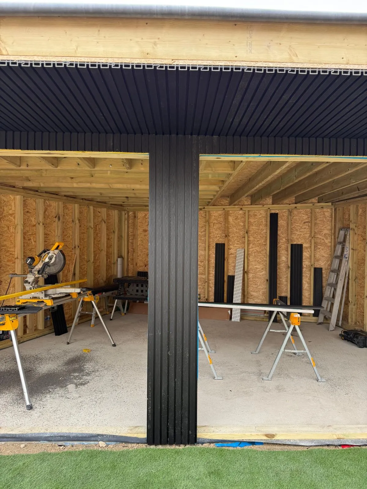 Garden room under construction with black composite cladding on the front