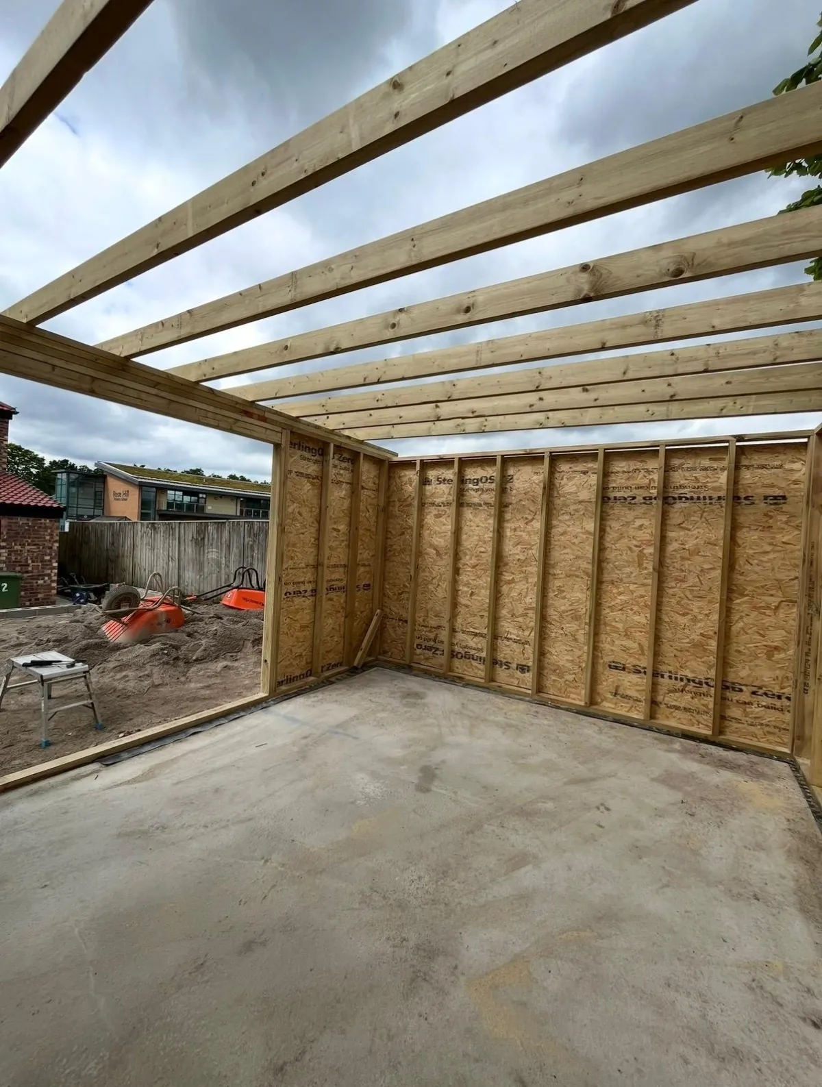 Garden room rafters and walls on a concrete base during construction