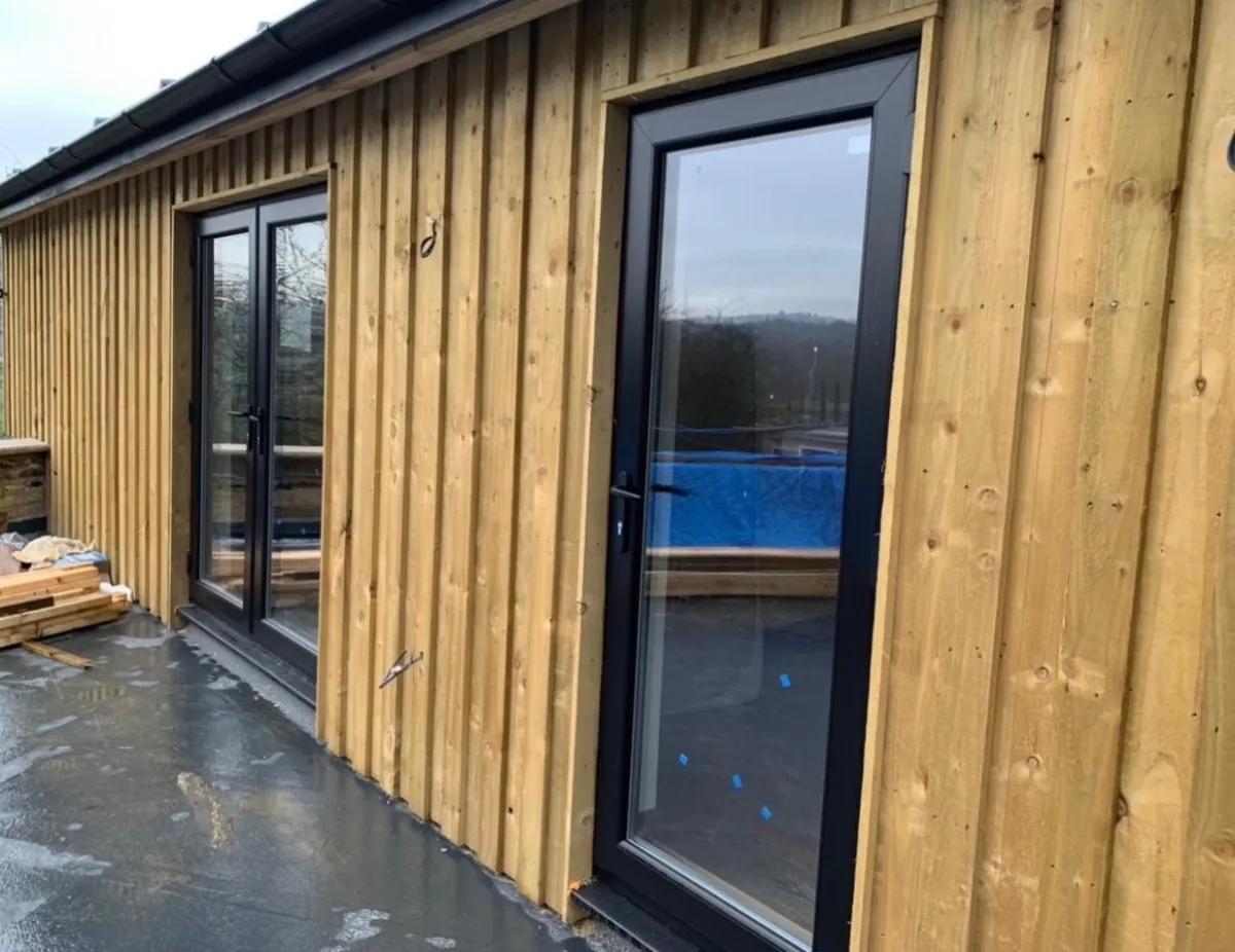 Timber-clad garden room with glazed doors nearing completion