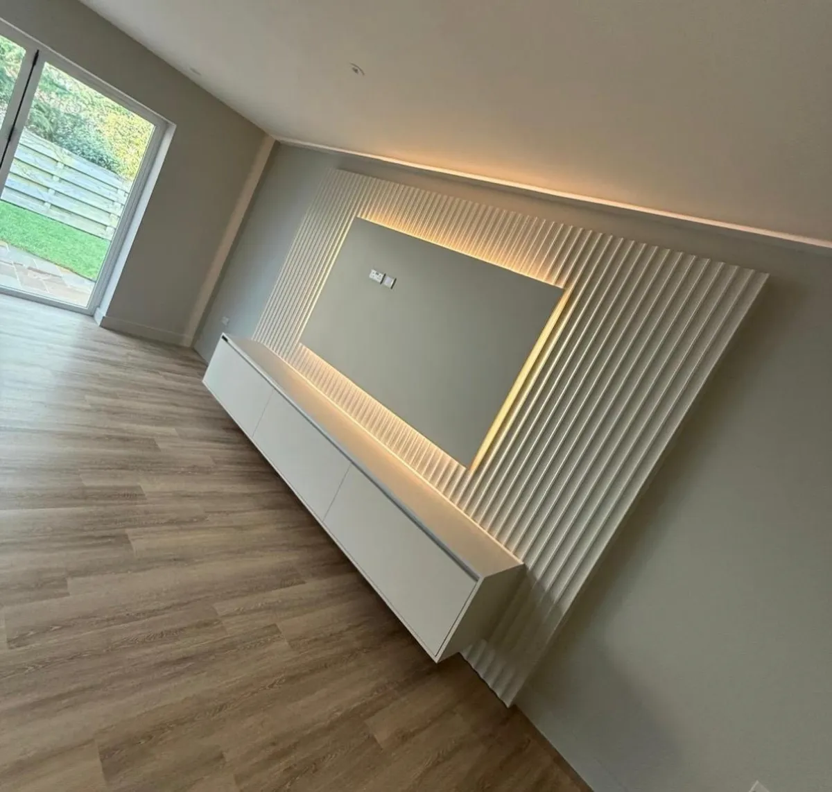Bespoke joinery media wall with fluted panels and LED lighting