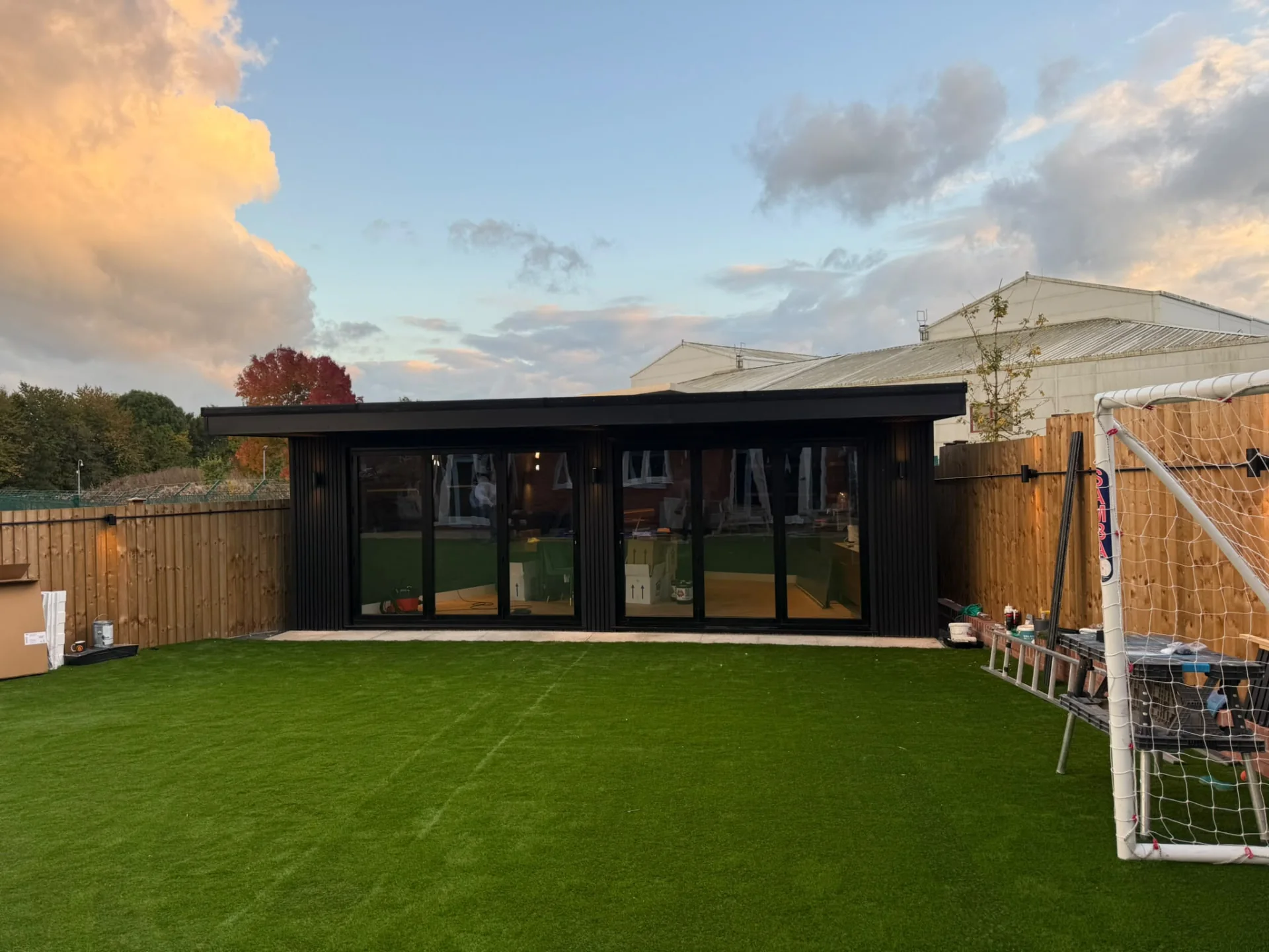 Wide garden view of a black-clad garden room with glazed doors