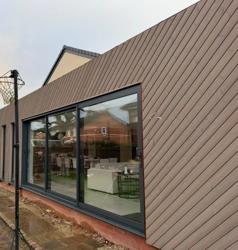 Timber-clad extension with large aluminium sliding doors